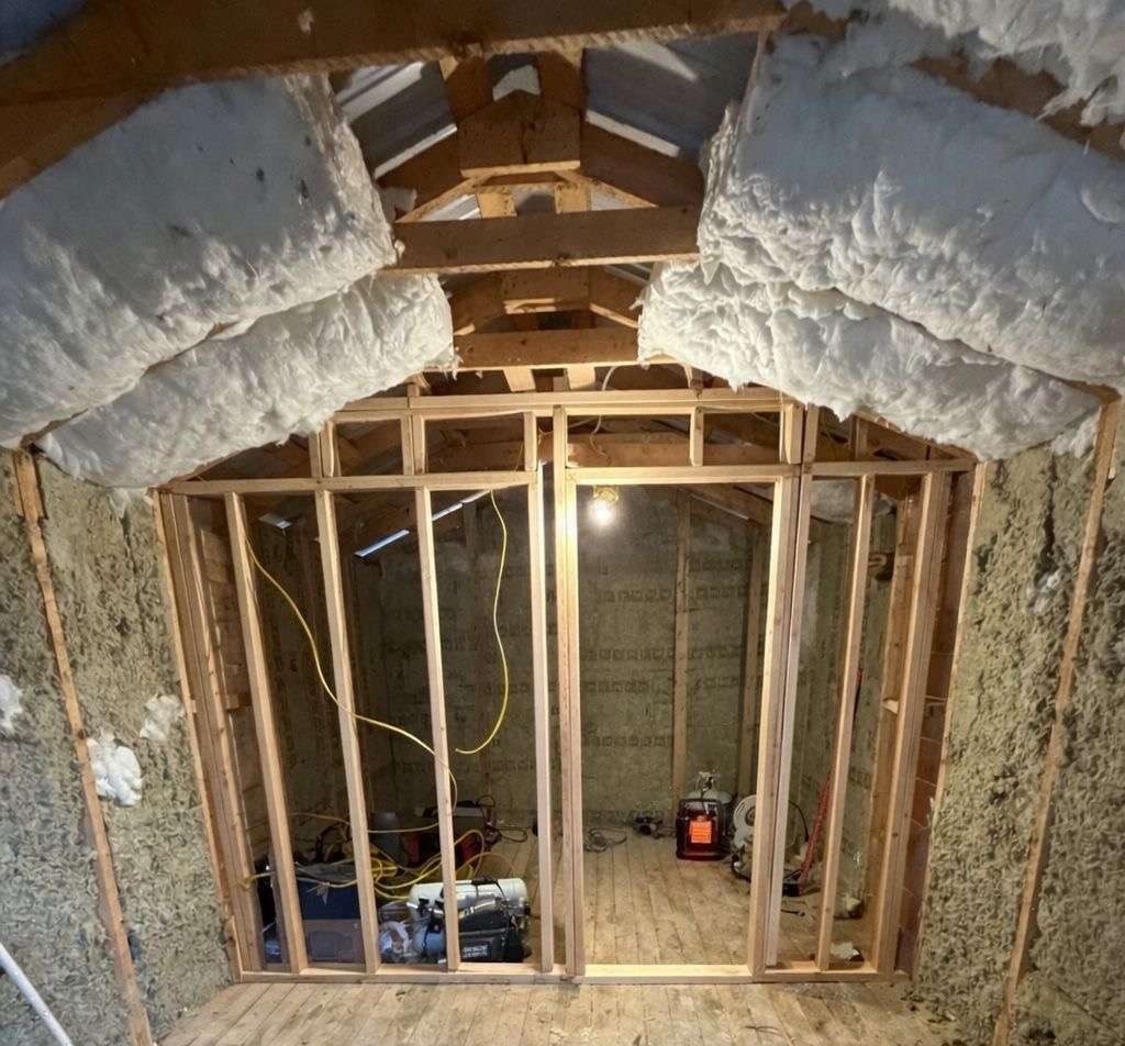 New stud wall framed under insulated rafters to divide the sauna from the changing room.